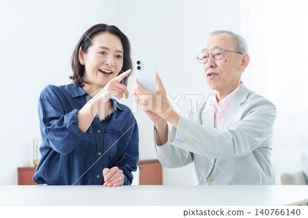 An elderly man learning about smartphones An elderly man learning about smartphones 140766140