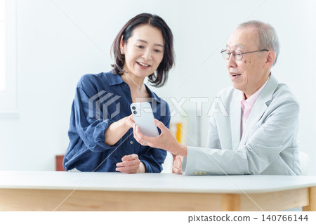 An elderly man learning about smartphones An elderly man learning about smartphones 140766144