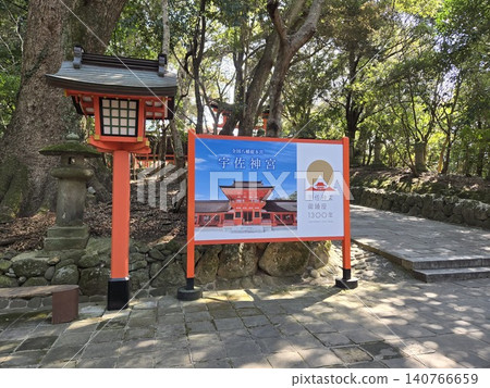 A sign commemorating the 1300th anniversary of the founding of Usa Shrine and a view of the lanterns along the approach to the shrine. 140766659
