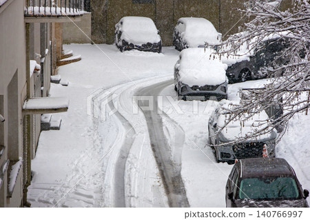 Cars parked on street under snow Cars parked on street under snow 140766997