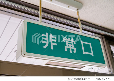 An emergency exit sign on an old building with a retro Showa-era atmosphere. An emergency exit sign on an old building with a retro Showa-era atmosphere. 140767360