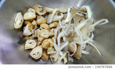 Fresh Mixed Sliced Straw and Oyster Mushrooms in a Stainless Steel Bowl Fresh Mixed Sliced Straw and Oyster Mushrooms in a Stainless Steel Bowl 140767666