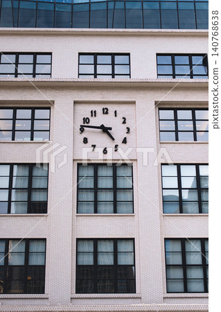 An analog wall clock in a building with white tiles. An analog wall clock in a building with white tiles. 140768638