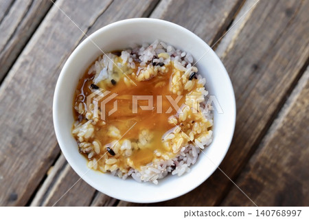 十六穀飯配生蛋:混合穀物米飯上放一個拌有醬油的生雞蛋。 十六穀飯配生蛋:混合穀物米飯上放一個拌有醬油的生雞蛋。 140768997