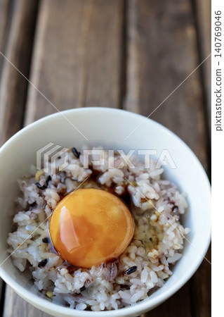 Rice with a raw egg on top of sixteen-grain rice with a drizzle of soy sauce. Rice with a raw egg on top of sixteen-grain rice with a drizzle of soy sauce. 140769046