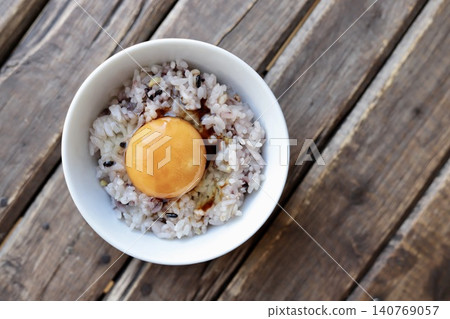 十六粒飯上放一顆生雞蛋,淋上少許醬油。 十六粒飯上放一顆生雞蛋,淋上少許醬油。 140769057