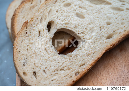 Cutting pieces of sourdough bread. Sourdough is a type of bread leavened naturally using a fermented starte a mixture of flour and water rather than commercial yeast. Cutting pieces of sourdough bread. Sourdough is a type of bread leavened naturally using a fermented starte a mixture of flour and water rather than commercial yeast. 140769172