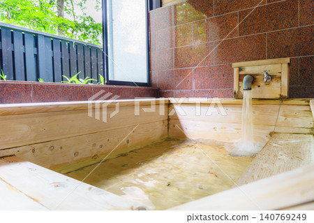 A family bath with a cypress wood tub and still life photographs of the hot spring. 140769249