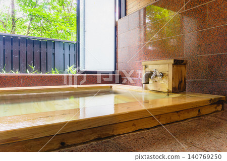 A family bath with a cypress wood tub and still life photographs of the hot spring. 140769250