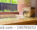 A family bath with a cypress wood tub and still life photographs of the hot spring. 140769252