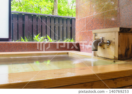 A family bath with a cypress wood tub and still life photographs of the hot spring. 140769253