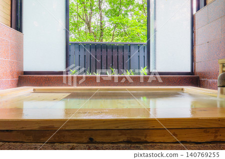 A family bath with a cypress wood tub and still life photographs of the hot spring. 140769255