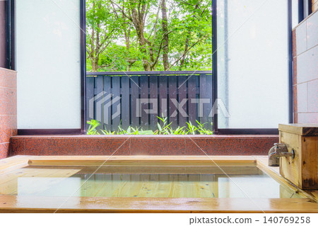 A family bath with a cypress wood tub and still life photographs of the hot spring. 140769258