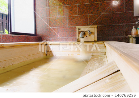 A family bath with a cypress wood tub and still life photographs of the hot spring. 140769259