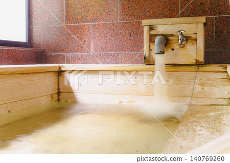 A family bath with a cypress wood tub and still life photographs of the hot spring. 140769260