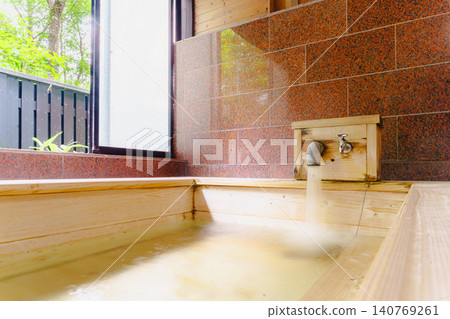 A family bath with a cypress wood tub and still life photographs of the hot spring. 140769261