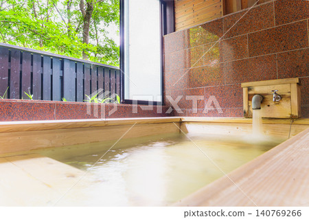 A family bath with a cypress wood tub and still life photographs of the hot spring. 140769266