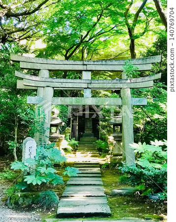 石砌鳥居和通往神社的小路，周圍綠樹環繞——寧靜的日本風格。 140769704