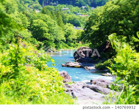 美麗的藍色溪流和山谷景色，四周環繞著鬱鬱蔥蔥的青山。 140769932