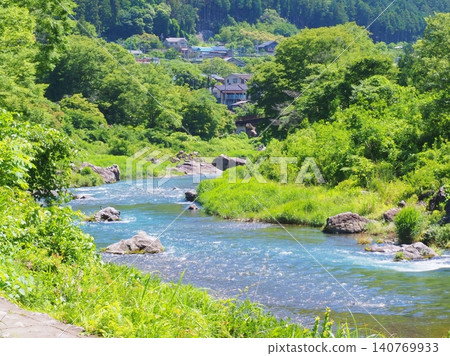一條美麗的藍色溪流蜿蜒流淌在鬱鬱蔥蔥的鄉村景色中。 一條美麗的藍色溪流蜿蜒流淌在鬱鬱蔥蔥的鄉村景色中。 140769933