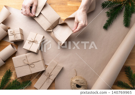 Folding Kraft Paper Around Christmas Gift Box Folding Kraft Paper Around Christmas Gift Box 140769965