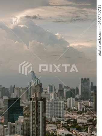 A modern metropolis unfolds beneath a dramatic, cloud-swept sky. Sleek skyscrapers rise above dense urban neighborhoods, blending contemporary design with bustling city life. In the distance, a A modern metropolis unfolds beneath a dramatic, cloud-swept sky. Sleek skyscrapers rise above dense urban neighborhoods, blending contemporary design with bustling city life. In the distance, a 140770735