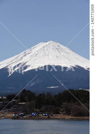 The pure white Mount Fuji rises majestically on the opposite shore of Lake Kawaguchi, with Mount Komitake nestled on its slopes. The pure white Mount Fuji rises majestically on the opposite shore of Lake Kawaguchi, with Mount Komitake nestled on its slopes. 140771009