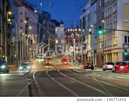 Bustling urban evening scene showcasing moving vehicles illuminated by flowing city lights and motion 140771458