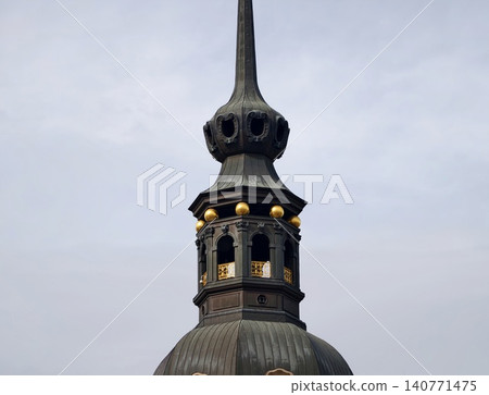 Gothic tower imagery. Dramatic scene highlighting vintage gothic steeple against overcast sky for storytelling Gothic tower imagery. Dramatic scene highlighting vintage gothic steeple against overcast sky for storytelling 140771475