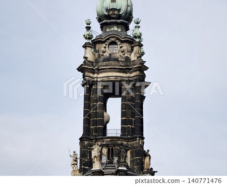 Artistic bell tower with detailed features. Ornamental steeple featuring arched openings and carved recesses Artistic bell tower with detailed features. Ornamental steeple featuring arched openings and carved recesses 140771476