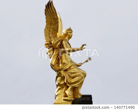 Bright celestial sculpture. Statue of angel with radiant wings and serene expression in soft light Bright celestial sculpture. Statue of angel with radiant wings and serene expression in soft light 140771490