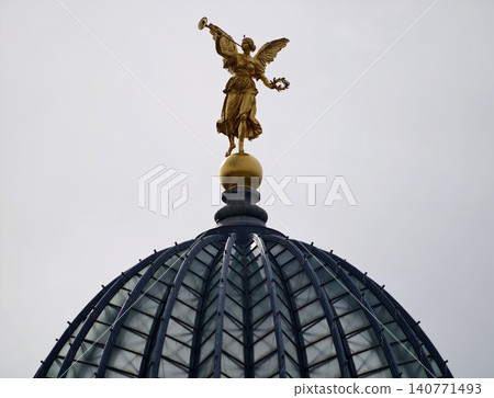 Refined gilded angel statue featuring wings and laurel crown beneath protective glass enclosure Refined gilded angel statue featuring wings and laurel crown beneath protective glass enclosure 140771493