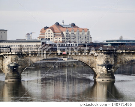 Timeless stone bridge stretching across serene water with nearby city skyline and subtle figures Timeless stone bridge stretching across serene water with nearby city skyline and subtle figures 140771496