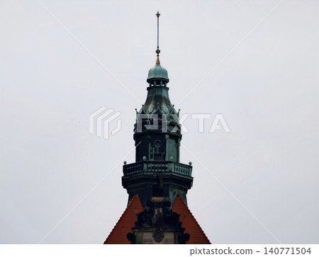 Quiet urban landscape showcasing vibrant green tower adorned with traditional building characteristics Quiet urban landscape showcasing vibrant green tower adorned with traditional building characteristics 140771504