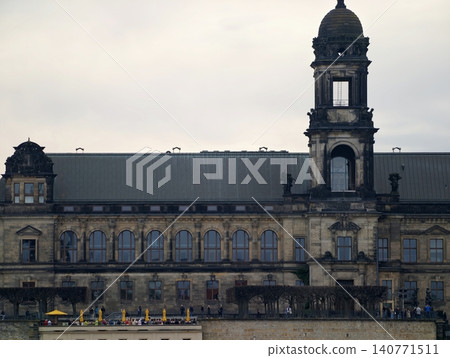Ancient riverside structure. Historic edifice with layered facade and cloudy skies reflected in water Ancient riverside structure. Historic edifice with layered facade and cloudy skies reflected in water 140771511