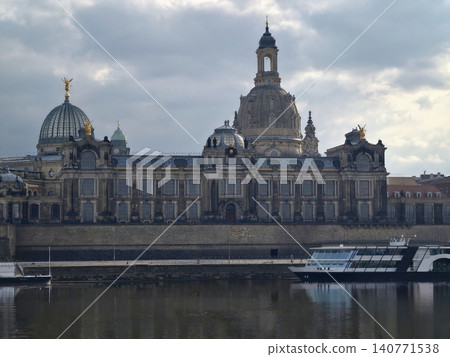 Calm water mirrors sunset city skyline. Serene riverfront scene with soft light and gentle ripples 140771538
