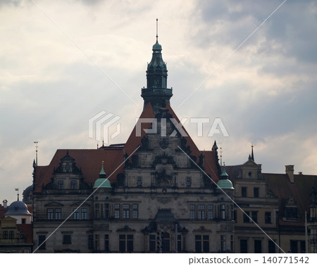 Clouded sky cast over heritage buildings featuring steep roofs and ornate architectural details Clouded sky cast over heritage buildings featuring steep roofs and ornate architectural details 140771542