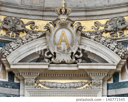 Majestic royal symbol gracing ornate historic palace entrance illuminated by natural sunlight Majestic royal symbol gracing ornate historic palace entrance illuminated by natural sunlight 140771545