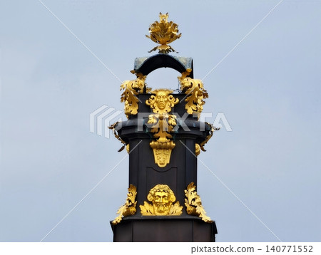 Sophisticated decorative artwork showcasing mask with laurel motifs and elaborately sculpted columns Sophisticated decorative artwork showcasing mask with laurel motifs and elaborately sculpted columns 140771552