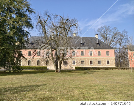 Bright pink front with open grounds. Vivid pink exterior with grassy open space and arched windows Bright pink front with open grounds. Vivid pink exterior with grassy open space and arched windows 140771645