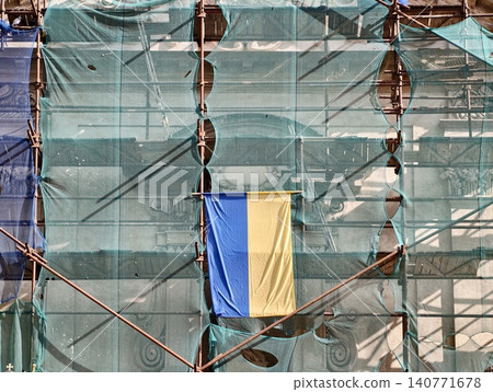 Faded building covered with national colors reflects ongoing community efforts toward renewal and hope 140771678