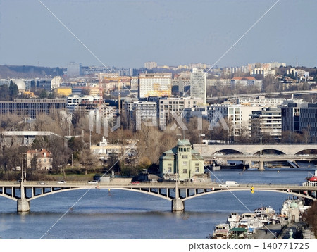 Urban river landscape. Contemporary bridges over calm water. Cityscape with twin bridges and modern buildings Urban river landscape. Contemporary bridges over calm water. Cityscape with twin bridges and modern buildings 140771725