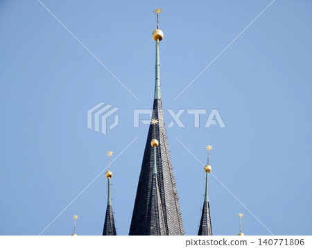 Graceful needleshaped tower reaching skyward with reflective surfaces and artistic craftsmanship Graceful needleshaped tower reaching skyward with reflective surfaces and artistic craftsmanship 140771806