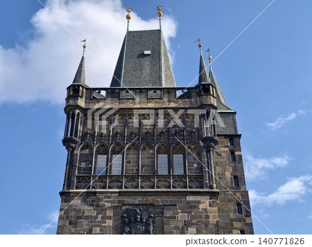 Fortified stone tower against clear sky. Stylish civic architecture with battlements and small windows 140771826