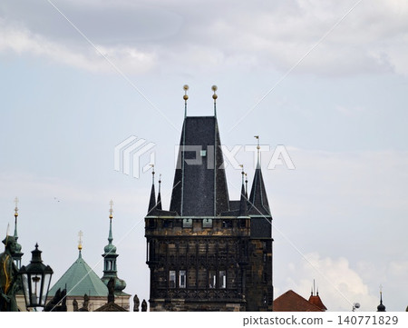 Medieval stone structure silhouette. Ancient tower with copper ornamentation and cloudy backdrop Medieval stone structure silhouette. Ancient tower with copper ornamentation and cloudy backdrop 140771829