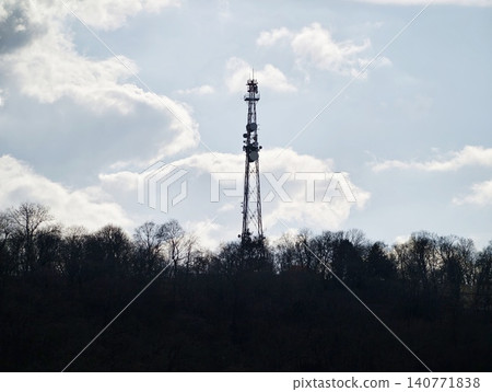 Rural tower backdrop. Silhouette of transmission mast in natural landscape under dramatic sky Rural tower backdrop. Silhouette of transmission mast in natural landscape under dramatic sky 140771838