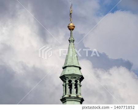 Small architectural copper spire adorned with gold accents and detailed rooftop embellishments Small architectural copper spire adorned with gold accents and detailed rooftop embellishments 140771852