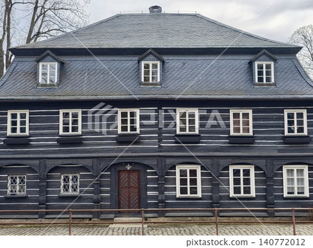 Vintage house facade. Oldfashioned wooden house featuring balanced window placement and dormer roof 140772012