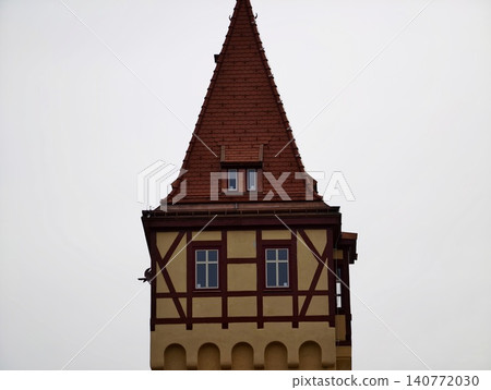 Ancient structure with distinctive roof. Medieval architectural element highlighted against cloudy sky scene Ancient structure with distinctive roof. Medieval architectural element highlighted against cloudy sky scene 140772030