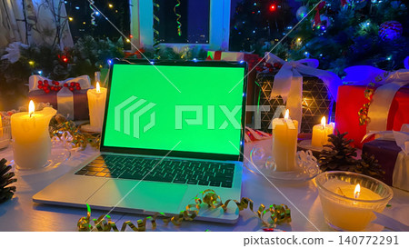 Beautifully packaged gift boxes, burning candles, pine cones, confetti, fir branch with red berries and striped caramel. Christmas advertising concept on computer. Laptop with a chroma key Beautifully packaged gift boxes, burning candles, pine cones, confetti, fir branch with red berries and striped caramel. Christmas advertising concept on computer. Laptop with a chroma key 140772291